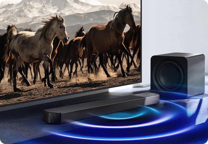 TV 앞에 사운드바가 설치되어 있으며, 사운드바에서 음향효과가 나오고 있습니다.