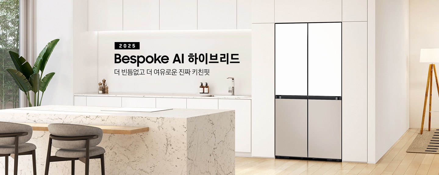 2025 Bespoke AI 하이브리드. 더 빈틈없고 더 여유로운 진짜 키친핏. 화이트톤의 주방 인테리어컷으로 냉장고장에 4도어 냉장고가 설치되어 있습니다. 냉장고 좌측으로는 동일한 화이트톤 상하부장과 수전, 오브제가 나와있으며 우측으로는 스탠드 조명이 나와있고 앞쪽에는 대리석 아일랜드 식탁이 나와있는 이미지 입니다.