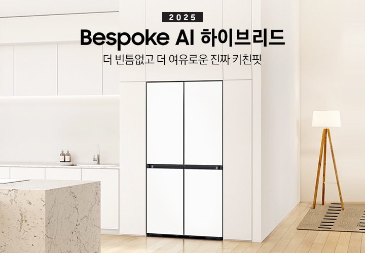 2025 Bespoke AI 하이브리드. 더 빈틈없고 더 여유로운 진짜 키친핏. 화이트톤의 주방 인테리어컷으로 냉장고장에 4도어 냉장고가 설치되어 있습니다. 냉장고 좌측으로는 동일한 화이트톤 상하부장과 수전, 오브제가 나와있으며 우측으로는 스탠드 조명이 나와있고 앞쪽에는 대리석 아일랜드 식탁이 나와있는 이미지 입니다.