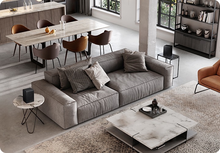 거실 소파 양옆 테이블 위에 리어스피커가 설치되어 있습니다.