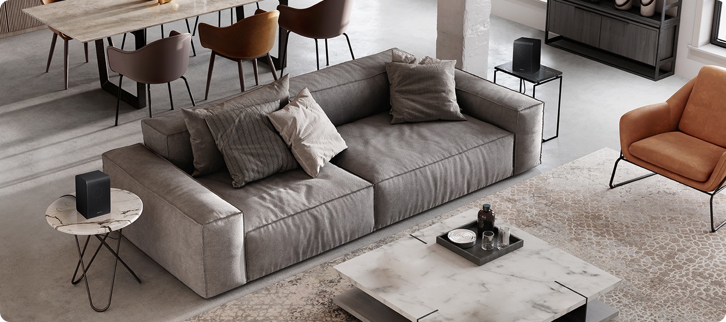 거실 소파 양옆 테이블 위에 리어스피커가 설치되어 있습니다.