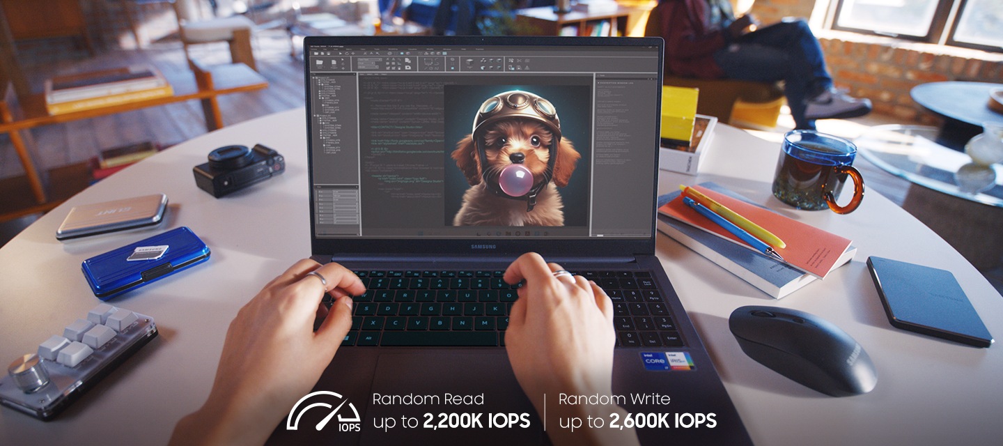 한 사람이 카페의 원형 테이블에서 노트북으로 헬멧을 쓴 강아지가 풍선껌을 부는 AI 이미지를 작업하고 있는 모습이 보이며, 테이블에는 마우스, 카메라, 볼펜, 노트, 물컵 등이 놓여져 있는 모습이 보이고 있습니다.