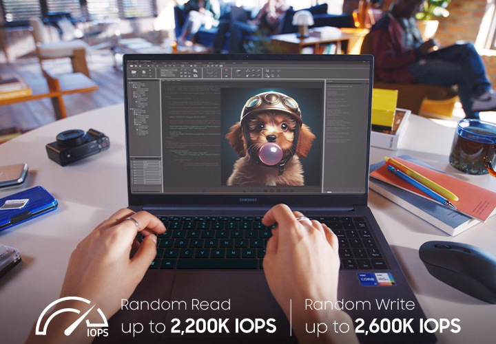 한 사람이 카페의 원형 테이블에서 노트북으로 헬멧을 쓴 강아지가 풍선껌을 부는 AI 이미지를 작업하고 있는 모습이 보이며, 테이블에는 마우스, 카메라, 볼펜, 노트, 물컵 등이 놓여져 있는 모습이 보이고 있습니다.