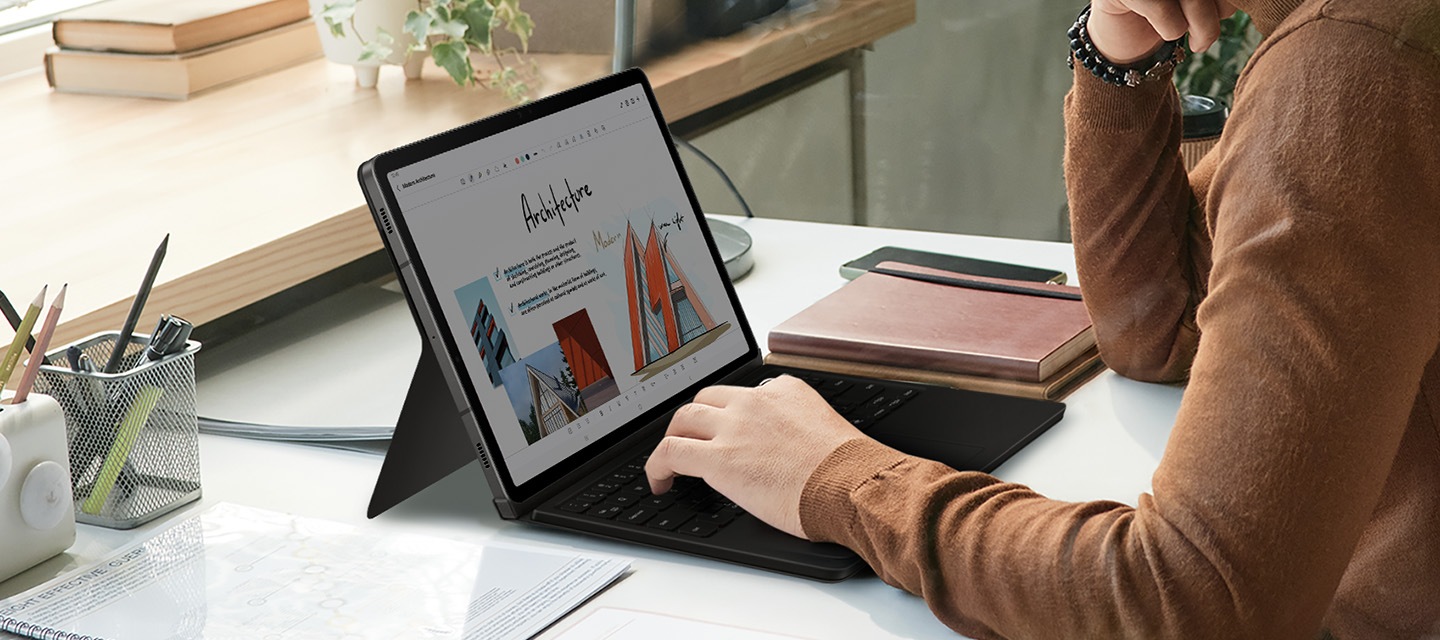 한 남성이 키보드 북커버에 손을 올리고 갤럭시 탭을 사용하고 있는 이미지가 보이고 있습니다.