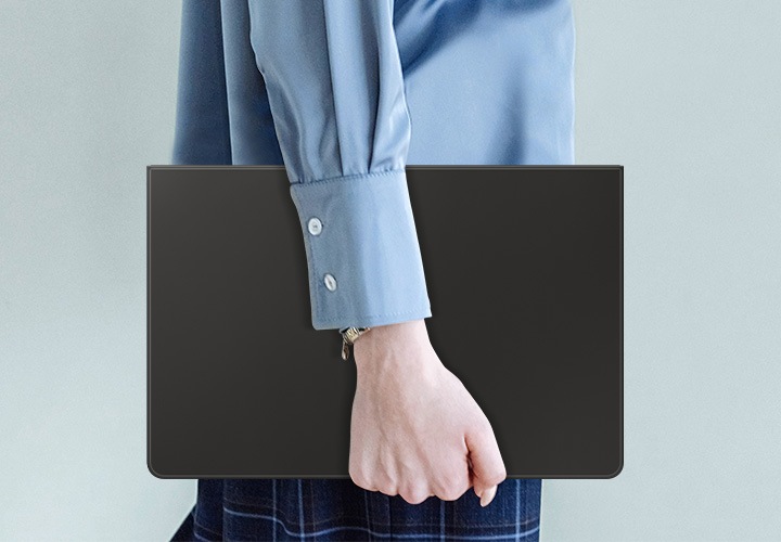 파란색 셔츠를 입은 사람이 슬림 키보드 북커버를 부착한 갤럭시 탭 S9을 들고 걸어가고 있는 이미지가 보이고 있습니다.