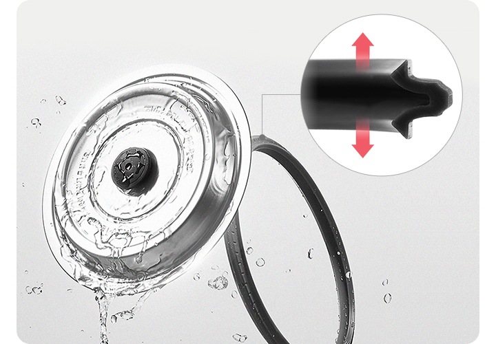 밥솥의 스테인리스 뚜껑과 고무 패킹이 분리되어 있고 물이 튀는듯한 이미지로 세척이 쉽다는 것을 설명하고 파워 압착 패킹의 단면도 상세히 보이고 있습니다. 고무 패킹의 양쪽에는 각각 바깥을 향하고 있는 화살표가 보이고 있습니다.