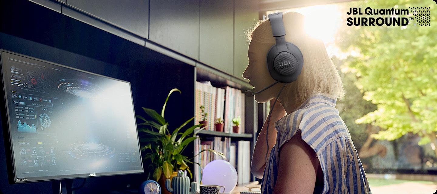 여성이 헤드셋을 착용한 상태로 PC 게임을 즐기고 있습니다.