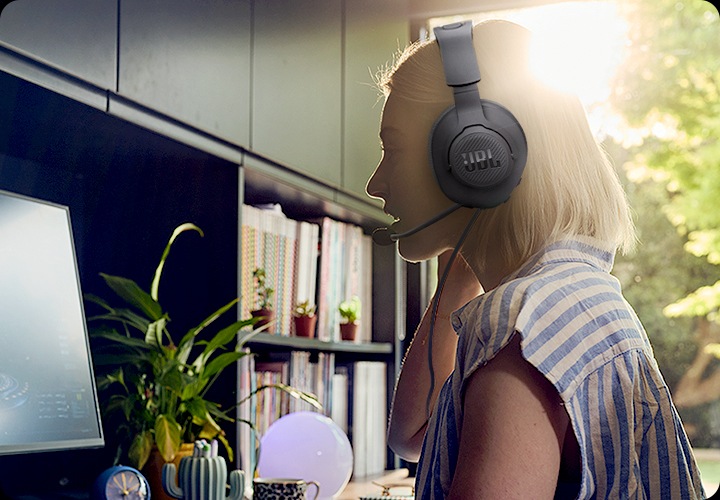 여성이 헤드셋을 착용한 상태로 PC 게임을 즐기고 있습니다.