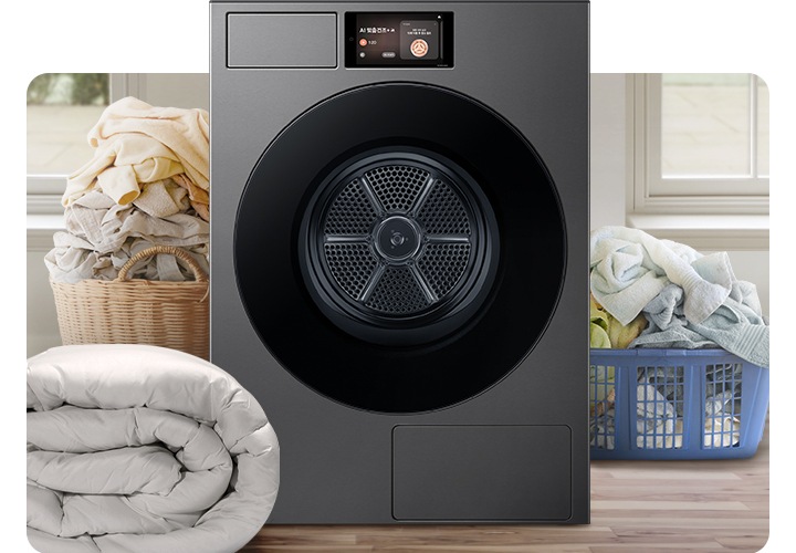 Bespoke AI 건조기가 중앙에 나와있고 좌측 뒷편 라탄 바구니에 의류가 가득 쌓여있고 앞쪽에 이불이 나와있습니다. 우측 파란색 플라스틱 바구니에도 수건 등 각종 옷감이 가득 쌓여있는 연출된 이미지입니다.