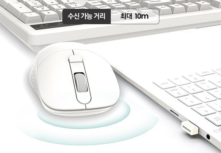 마우스의 리시버가 꽂힌 노트북의 측면과 흰색 키보드, 흰색 마우스가 보입니다. 마우스 위로 수신 가능 거리 최대 10m 라는 문구가 보입니다.