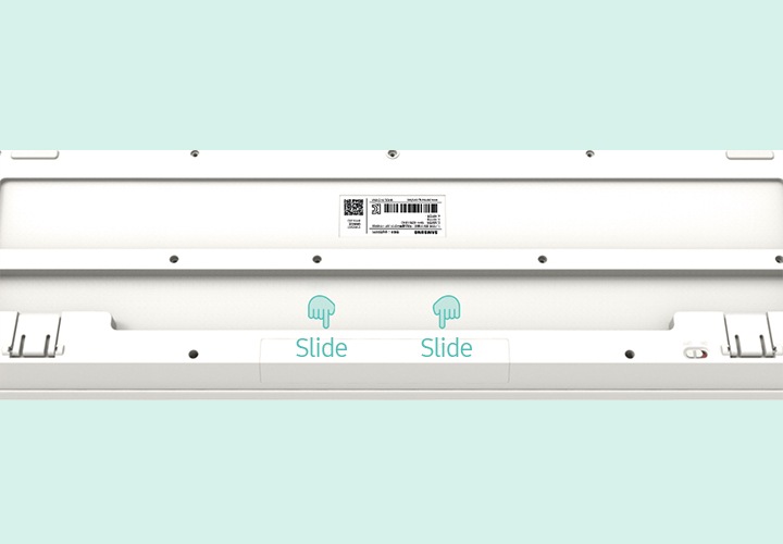키보드 바닥면의 이미지가 보이며 손가락 모양 아이콘으로 건전지 교체 방법을 보여주고 있습니다.