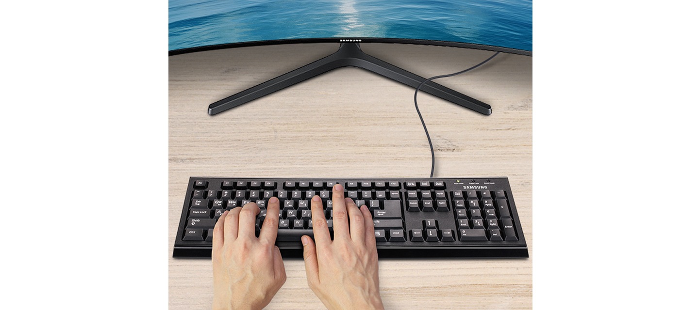 정면에 모니터와 검은색 키보드가 보이며 키보드에 양 손을 올려 둔 이미지가 보입니다.	