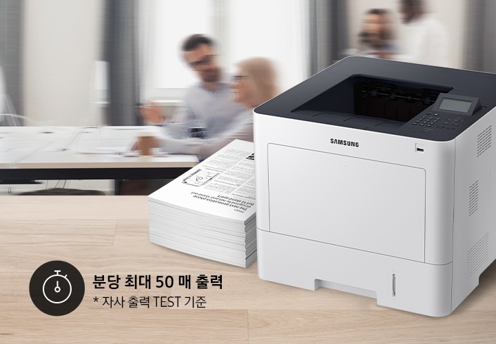 사람들이 모여 업무를 하고 있는 배경 앞에 프린터가 보이고 있습니다. 프린터 좌측에는 타이머 아이콘과 함께 “분당 최대 50매 출력”, “자사 출력 TEST 기준”이라는 텍스트가 보이고 있습니다.