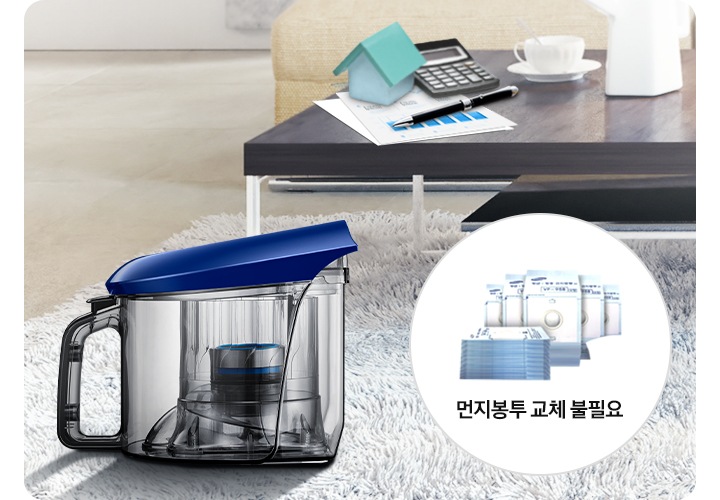 불투명하게 보이는 거실을 배경으로 이미지 오른쪽 하단 부분에는 동그란 흰색 원안에 먼지봉투 이미지와 필요 없다는 것을 알려주는 아이콘 표시와 함께 보이고 있고 이미지 왼쪾 하단 부분에는 연한 회색 색상의 카펫트 위에 먼지통의 옆모습 이미지가 보이고 있습니다.