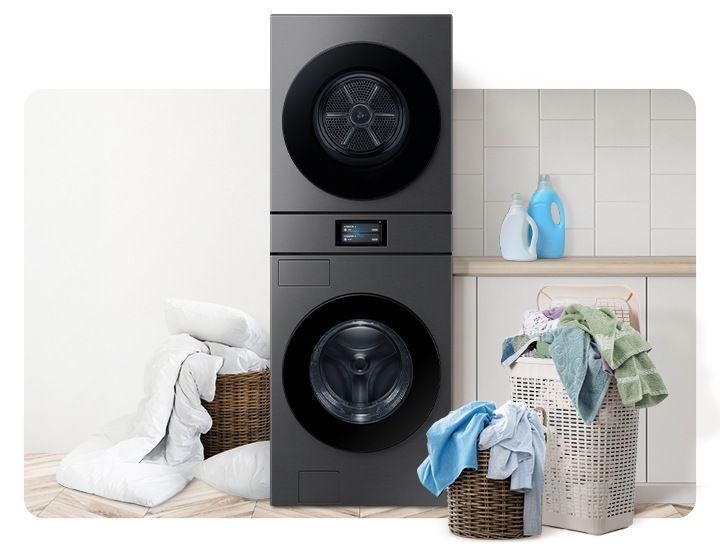 Bespoke AI 원바디가 중앙에 나와있고 좌측 뒷편 라탄 바구니에 의류가 가득 쌓여있고 앞쪽에 이불이 나와있습니다. 우측 파란색 플라스틱 바구니에도 수건 등 각종 옷감이 가득 쌓여있는 연출된 이미지입니다.