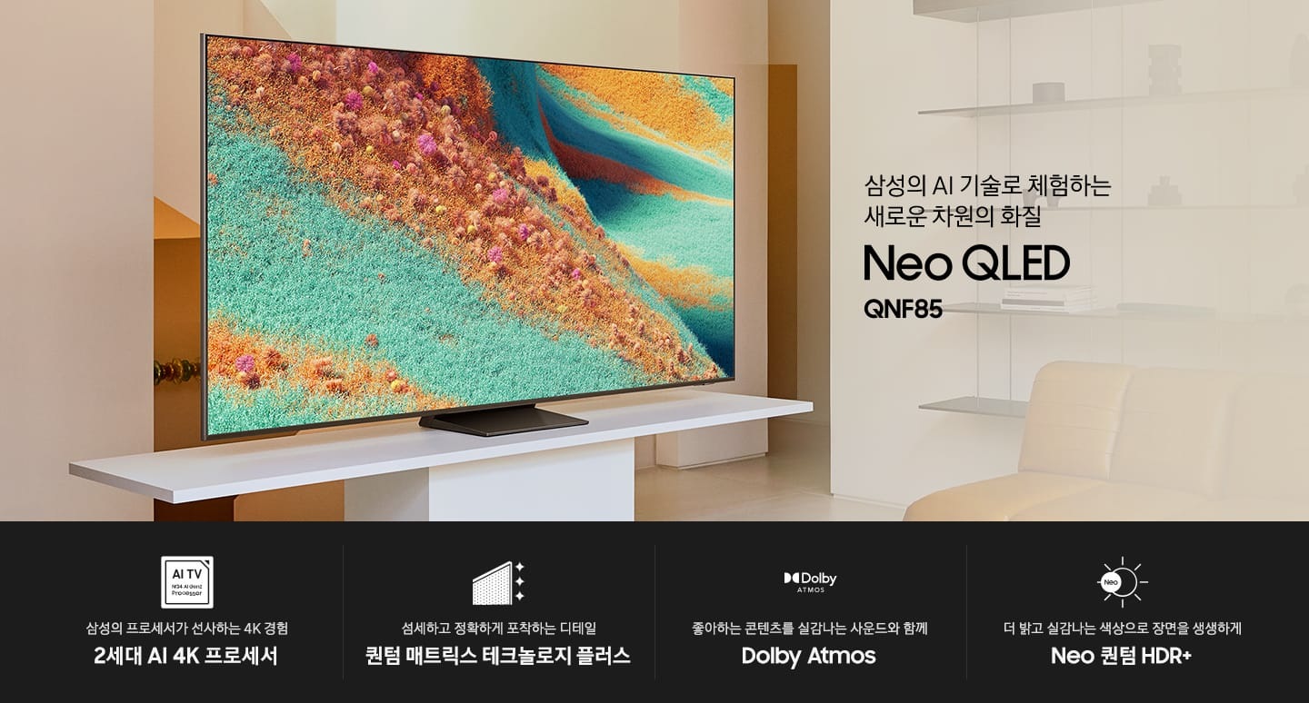 거실 장식장 위에 TV가 설치되어 있습니다. 삼성의 AI 기술로 체험하는 새로운 차원의 화질 Neo QLED QNF85 KV입니다.하단에는 삼성의 프로세서가 선사하는 4K 경험 2세대 AI 4K 프로세서, 섬세하고 정확하게 포착하는 디테일 퀀텀 매트릭스 테크놀로지 플러스, 좋아하는 콘텐츠를 실감나는 사운드와 함께 Dolby Atmos, 더 밝고 실감나는 색상으로 장면을 생생하게 Neo 퀀텀 HDR+ 문구와 아이콘이 있습니다.