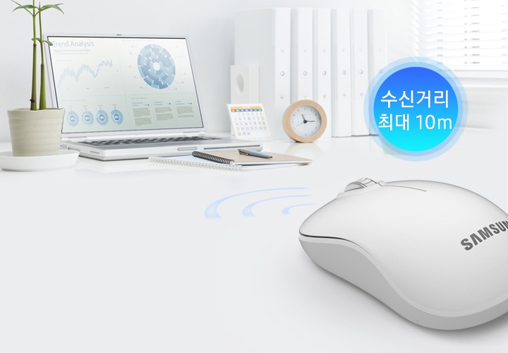 사진 상 멀리에 노트북이 있고 가까이에 회색 마우스가 있습니다. 마우스 위에 수신거리 최대 10m라는 글씨가 보입니다.