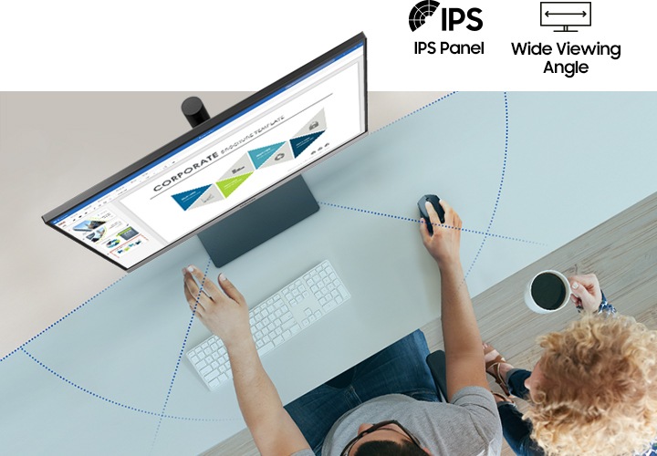 책상 위 모니터를 앞에 두고 앉은 두 사람이 보입니다.