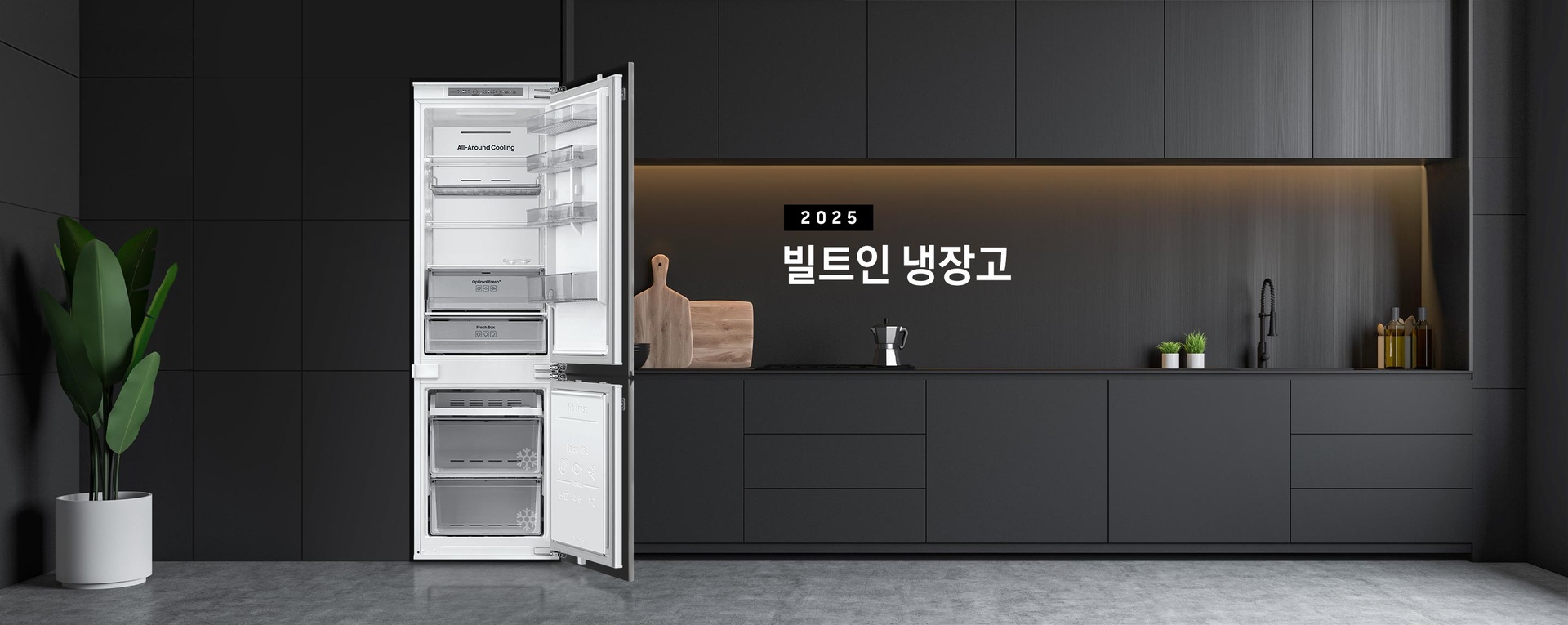 블랙톤 냉장고장에 빌트인 냉장고가 설치되어 있고 냉장고 상하칸 도어가 모두 열려있는 인테리어컷 입니다. 냉장고 좌측에는 큰 화분이, 우측에는 도마 등 각종 오브제가 하부장 위에 놓여있습니다.