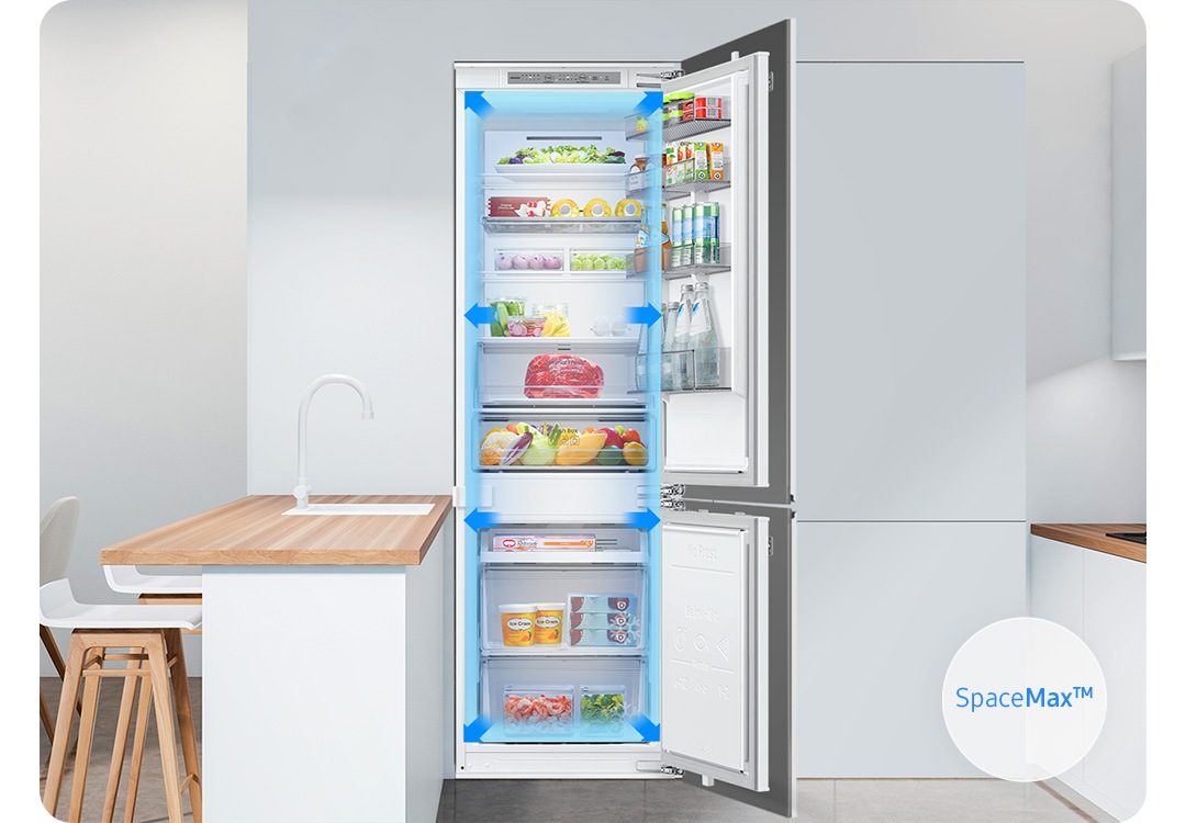 하얀색 냉장고장에 빌트인 냉장고가 설치되어 있고 상하칸 도어가 오픈되어 있습니다. 냉장고 내상에는 다양한 푸드와 음료가 가득 차 있습니다. 좌측 상단에는 SpaceMax™ 로고가 나와있습니다.