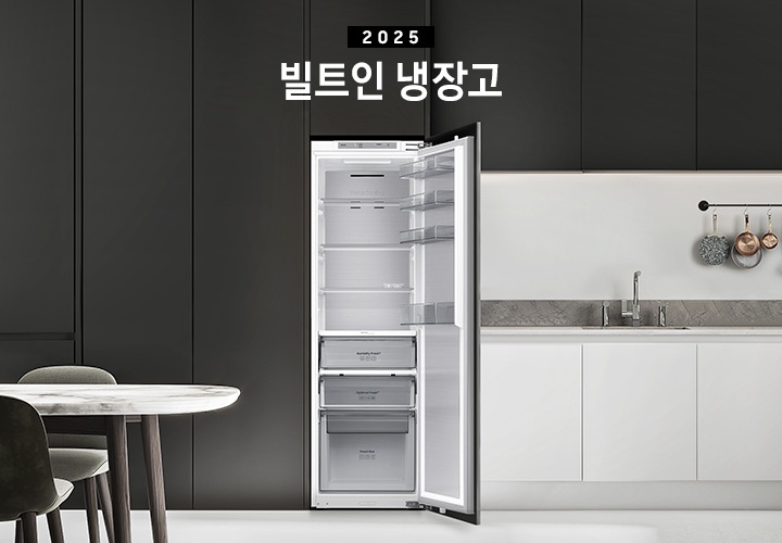 블랙톤 냉장고장에 빌트인 냉장고가 설치되어 있고 도어가 열려있는 인테리어컷 입니다. 냉장고 좌측에는 큰 화분이, 우측에는 도마 등 각종 오브제가 하부장 위에 놓여있습니다.