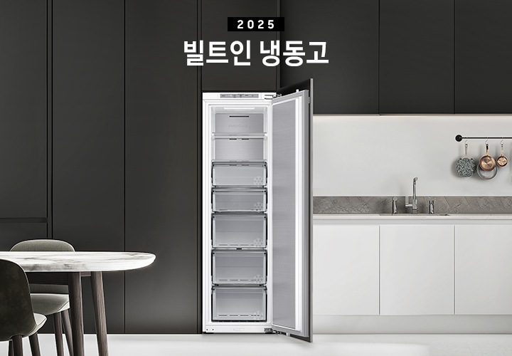 블랙톤 냉장고장에 빌트인 냉동고가 설치되어 있고 도어가 열려있는 인테리어컷 입니다. 냉장고 좌측에는 큰 화분이, 우측에는 도마 등 각종 오브제가 하부장 위에 놓여있습니다.