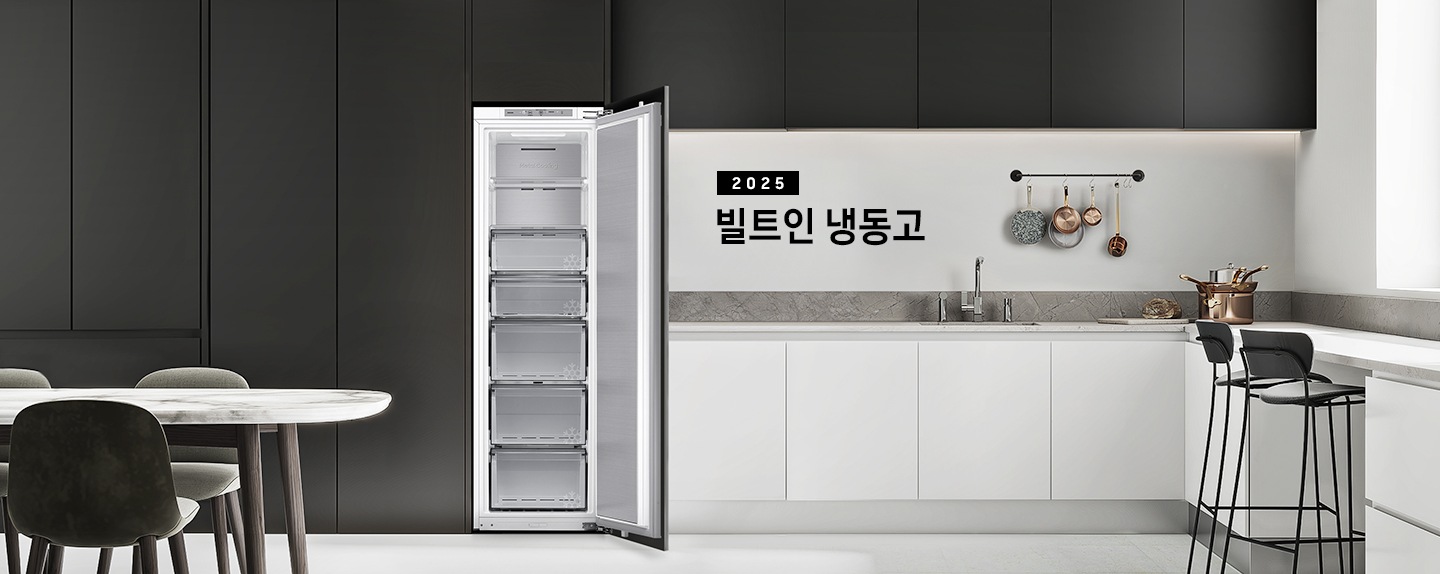 블랙톤 냉장고장에 빌트인 냉동고가 설치되어 있고 도어가 열려있는 인테리어컷 입니다. 냉장고 좌측에는 큰 화분이, 우측에는 도마 등 각종 오브제가 하부장 위에 놓여있습니다.