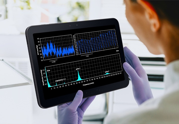실험실 가운과 장갑을 착용한 한 사람이 갤럭시 탭 액티브5 프로를 들고 있습니다. 다양한 그래프가 표시되어 장갑을 낀 상태에서도 기기가 원활하게 작동함을 알려줍니다.