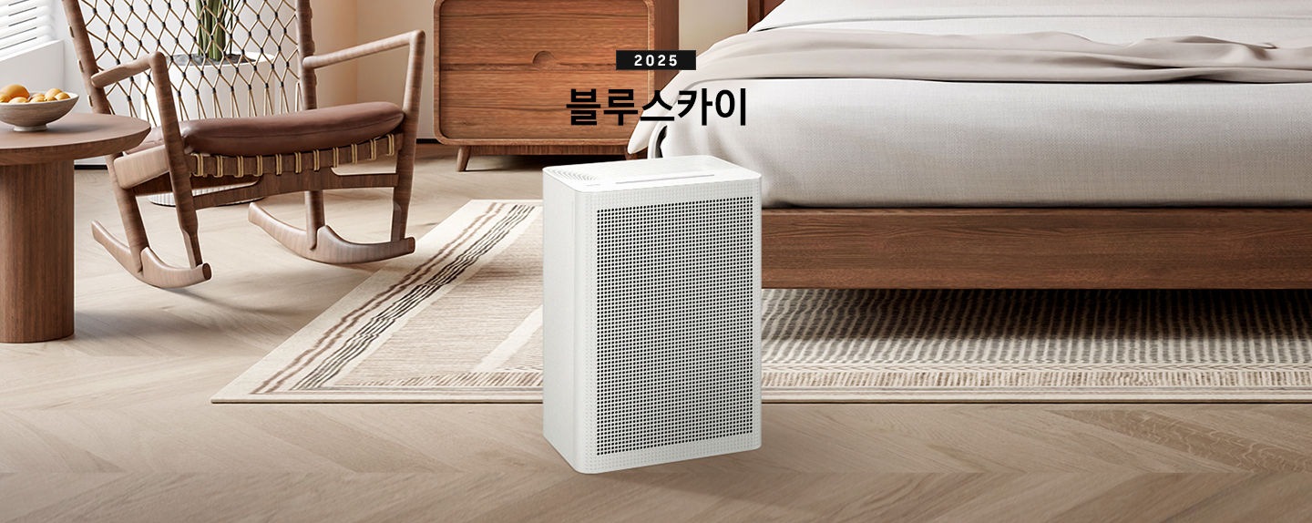 우드와 베이지 톤의 침실이 배경으로 보이고 있습니다. 이미지 중간 부분에는 블루스카이 3100 제품이 서있고 제품 이미지 상단 부분에는 2025 블루스카이 텍스트가 적혀 있습니다. 제품 이미지 왼쪽 부분에는 우드로 제작된 동그란 테이블과 흔들의자가 배치되어 있고 제품 이미지 오른쪽 부분에는 침대가 보이고 있습니다.