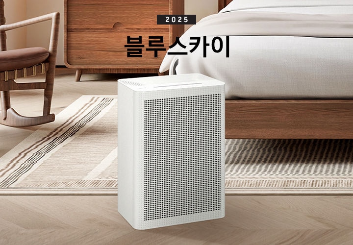 우드와 베이지 톤의 침실이 배경으로 보이고 있습니다. 이미지 중간 부분에는 블루스카이 3100 제품이 서있고 제품 이미지 상단 부분에는 2025 블루스카이 텍스트가 적혀 있습니다. 제품 이미지 왼쪽 부분에는 우드로 제작된 동그란 테이블과 흔들의자가 배치되어 있고 제품 이미지 오른쪽 부분에는 침대가 보이고 있습니다.