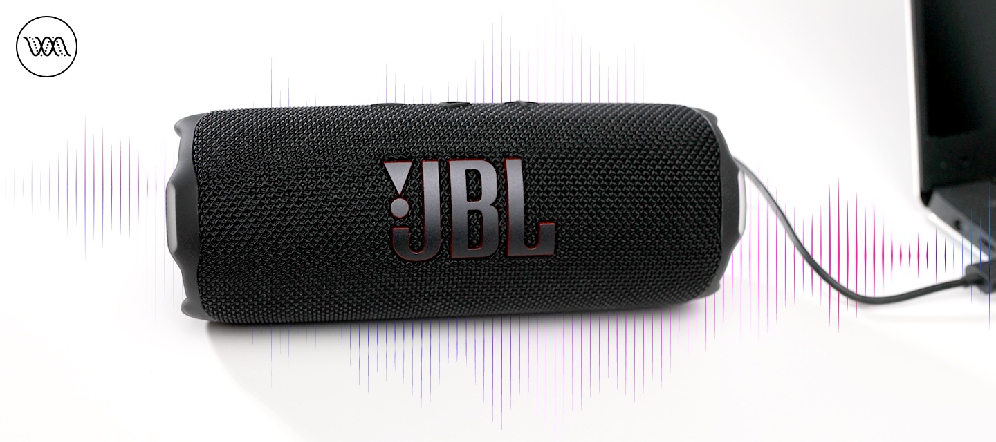 노트북에 스피커가 연결되어 있으며, 스피커 뒤로는 음향효과가 보입니다.