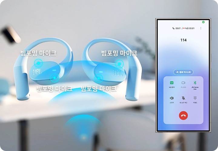 이어폰 옆으로 휴대폰이 보입니다. 이어폰에는 ‘빔포밍 마이크’ 위치가 표시되어 있으며, 휴대폰에는 114에 전화 건 화면이 보입니다. 이어폰과 휴대폰 뒤로는 사무공간이 흐릿하게 보입니다.