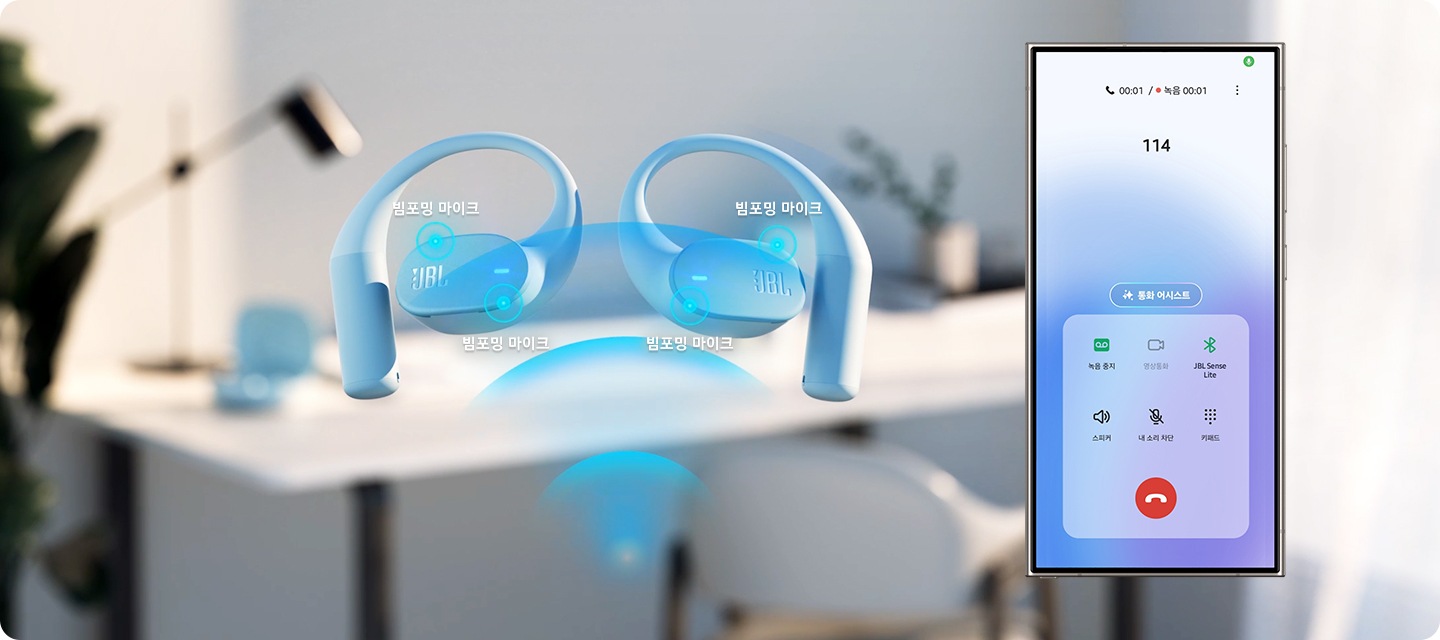 이어폰 옆으로 휴대폰이 보입니다. 이어폰에는 ‘빔포밍 마이크’ 위치가 표시되어 있으며, 휴대폰에는 114에 전화 건 화면이 보입니다. 이어폰과 휴대폰 뒤로는 사무공간이 흐릿하게 보입니다.