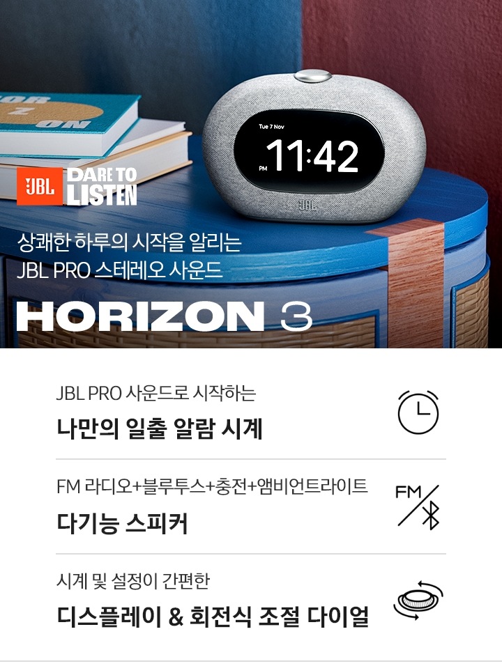 테이블 위에 HORIZON 3가 놓여 있습니다. HORIZON 3 뒤로는 책이 놓여 있습니다. 상쾌한 하루의 시작과 함께하는 JBL PRO 스테레오 사운드 HORIZON 3 KV입니다. 하단에는 JBL PRO 사운드로 시작하는 나만의 일출 알람 시계, FM 라디오+블루투스+충전 다기능 스피커, 시계 및 설정이 간편한 디스플레이 & 회전식 조절 다이얼 문구 및 아이콘이 있습니다.