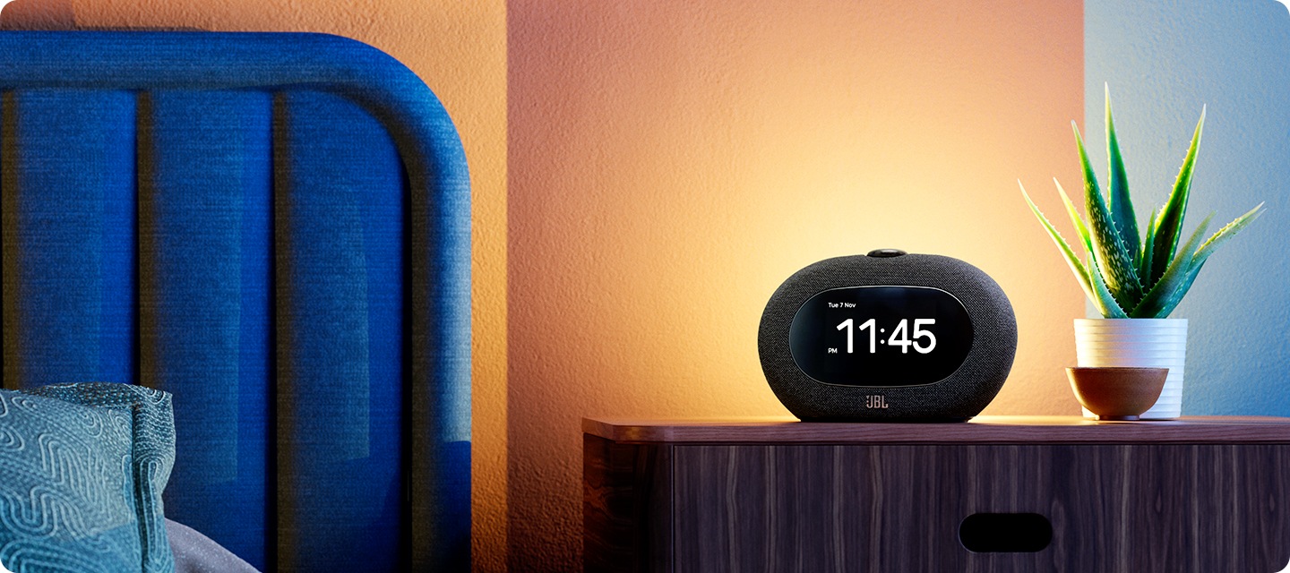 침대 옆 서랍 위에 HORIZON 3와 화분이 놓여 있습니다.