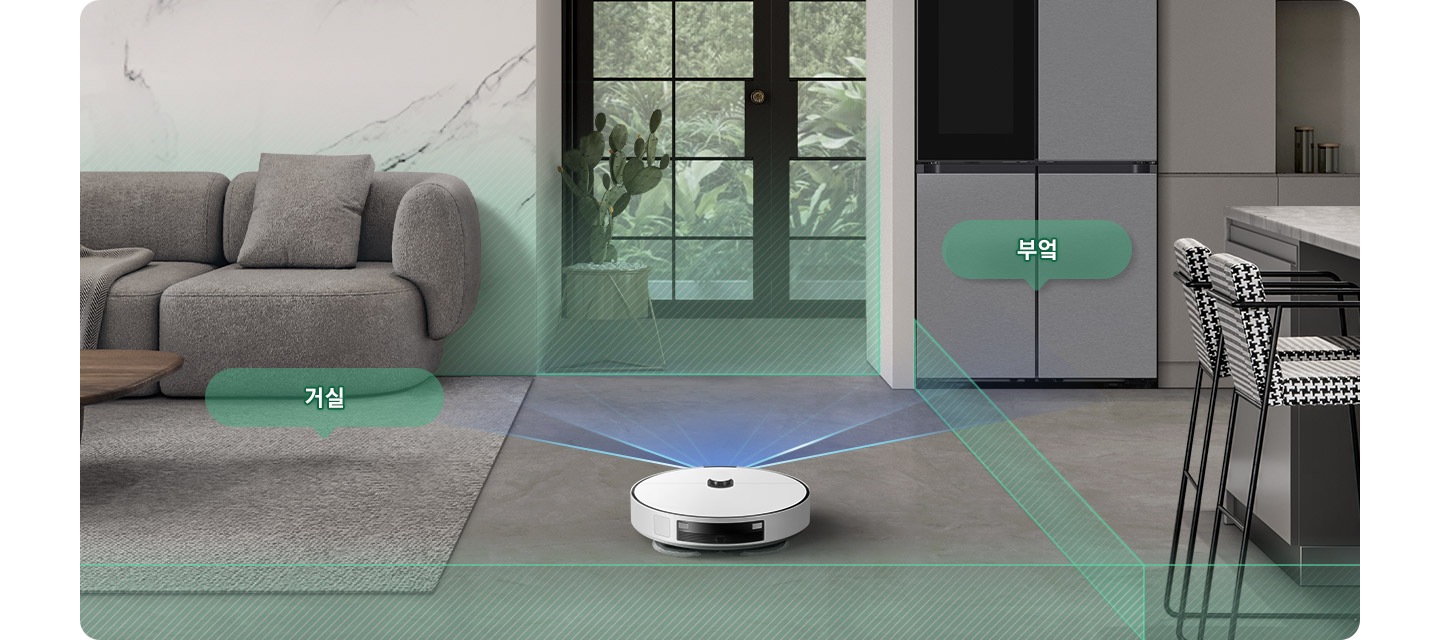 채도가 낮은 색상의 거실과 부엌을 배경으로 Bespoke AI 스팀 울트라의 뒷 모습이 이미지 중간 하단 부분에 있으며, 이미지 왼쪽 부분에는 회색의 카펫트가 카펫트 위에는 더 진한 회색의 소파와 어두운 색상의 우드 테이블이 놓여 있고 소파와 카펫트가 만나는 부분에는 반투명한 초록색 말풍선에 거실이라는 텍스트가 쓰여 있습니다. 이미지 오른쪽 부분에는 체크무늬의 높은 의자 2개가 회색 대리석의 주방 테이블 옆에 배치되어 있고 냉장고가 테이블 왼쪽 부분에 놓여 있으며 냉장고 앞부분에는 반투명한 초록색 말풍선에 부엌이라는 텍스트가 쓰여 있습니다. Bespoke AI 스팀 울트라가 집 안을 스캔해 거실과 주방을 초록색 빗금이 그려진 반투명 박스로 구분하며 각 공간을 인식하는 모습을 보여주고 있습니다.