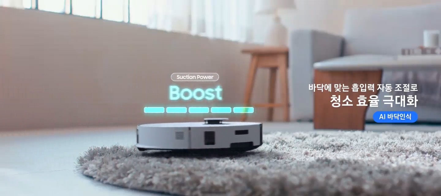 이미지 오른쪽 부분에는 바닥에 맞는 흡입력 자동 조절로 청소 효율 극대화로 텍스트가 쓰여 있으며, 장모 카펫을 청소하고 있는 Bespoke AI 스팀 울트라의 측면 모습이 있습니다. Bespoke AI 스팀 울트라의 상단에는 Suction Power Boost로 텍스트가 쓰여 있습니다.