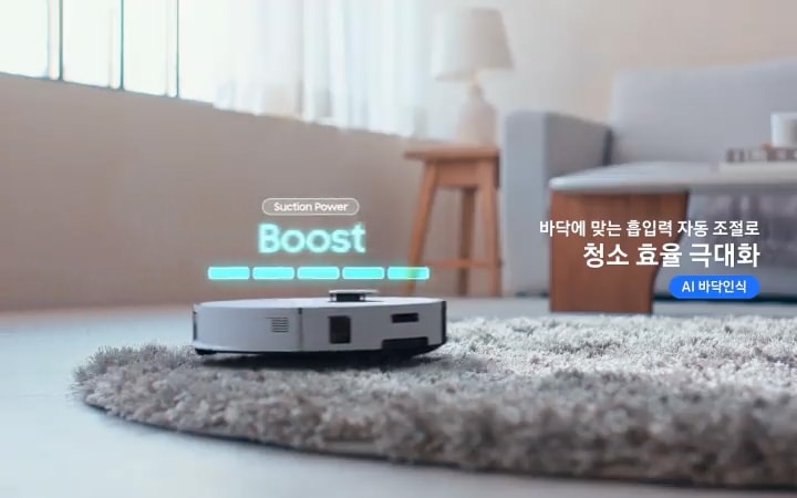 이미지 오른쪽 부분에는 바닥에 맞는 흡입력 자동 조절로 청소 효율 극대화로 텍스트가 쓰여 있으며, 장모 카펫을 청소하고 있는 Bespoke AI 스팀 울트라의 측면 모습이 있습니다. Bespoke AI 스팀 울트라의 상단에는 Suction Power Boost로 텍스트가 쓰여 있습니다.
