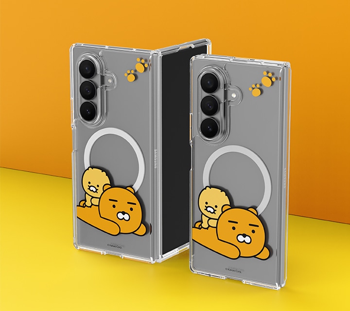 주황색 벽과 노란색 바닥으로 되어있는 공간에 카카오프렌즈 춘식&라이언 버라이어티 마그넷 케이스를 장착한 갤럭시 Z 폴드7 두 대가 세워져 있습니다. 왼쪽 제품은 90도로 펼쳐져 있고 오른쪽은 완전히 접혀 있습니다.