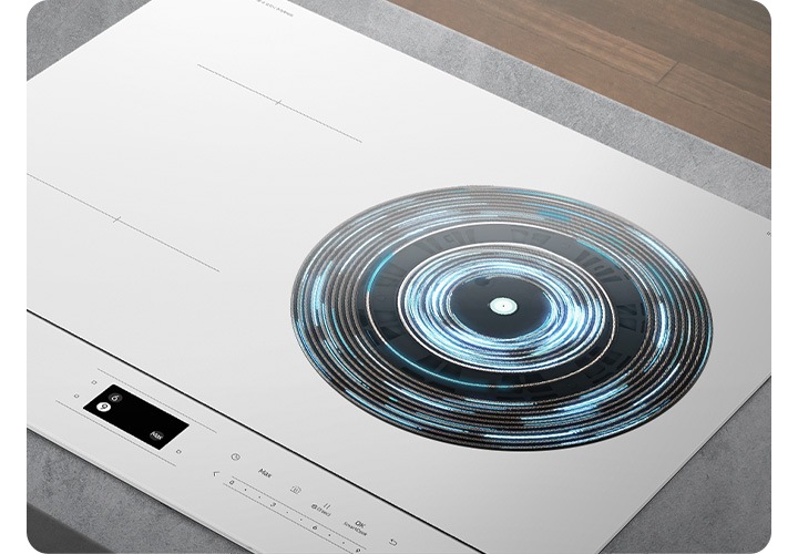 오른쪽 상단에는 진한 갈색의 마룻 바닥이 보입니다. 그 아래 회색 상판이 깔린 주방 테이블 위로 인덕션이 설치되어 있는 모습이 보입니다. 인덕션의 오른쪽 화구 부분 가열 영역이 파란색 선들로 원형으로 표현되어 있습니다.