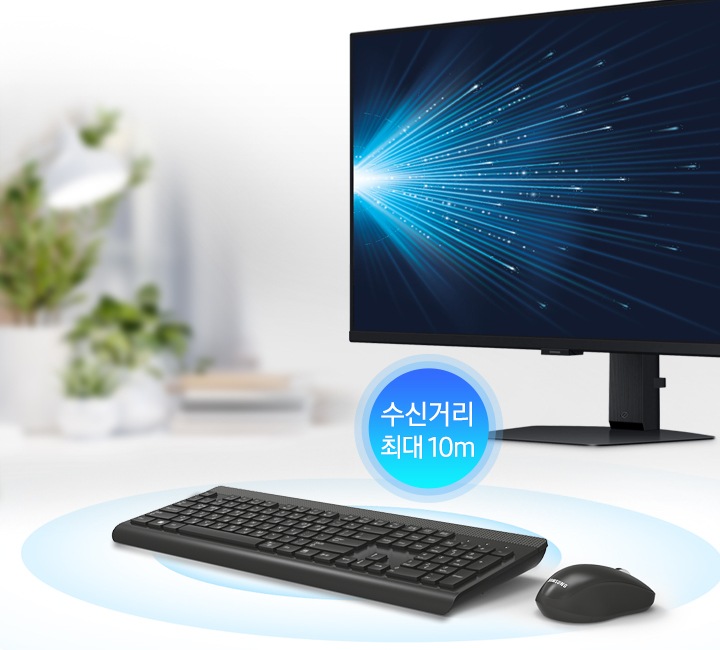 책상 위에 모니터와 키보드, 마우스가 놓여있고 수신거리 최대 10m 글씨가 보입니다.