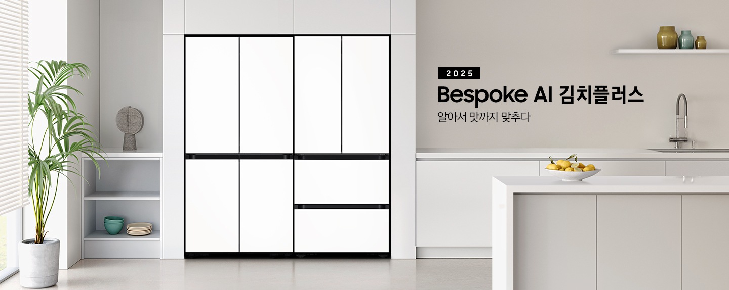 2025 Bespoke AI 김치플러스, 알아서 맛까지 맞추다 키친핏 KV 인테리어컷입니다. 좌측에 Bespok 냉장고 4도어와 Bespoke 김치플러스 4도어 제품이 키친핏으로 설치되어 있습니다. 주방은 화이트와 라이트 그레이 베이지톤으로 이루어져 있으며, 냉장고와 김치냉장고가 설치되어 있는 좌측에 바깥이 보이는 창과 하얀색 블라인드가 내려져 있고 식물이 놓여져 있습니다. 그리고 2층 수납장에 인테리어 소품과 접시, 그릇이 놓여져 있습니다. 인테리어컷 우측에는 주방 하부장에 수전과 싱크볼, 위에는 유리 화병 3개, 하부장 앞에는 레몬 여러개가 담긴 접시가 올려져 있는 아일랜드 식탁이 보여집니다.