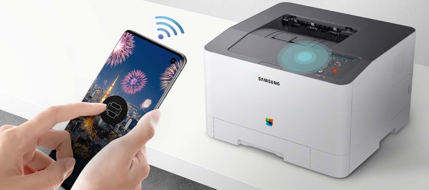 하얀색 책상 위에 제품을 오른쪽 위에서 내려본 이미지가 중간에 배치하여 있고 이미지 왼쪽 부분에 스마트폰 화면에 프린터 아이콘을 누르고 있는 사람의 손이 배치하여 있습니다.