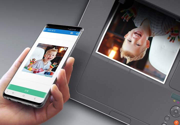 검정 색상의 나무 책상에 제품의 왼쪽 위에서 내려본 이미지가 있고 스마트폰을 제품 이미지 상단에 NFC 태그 스티커가 붙어있는 부분에 태그하는 이미지입니다.