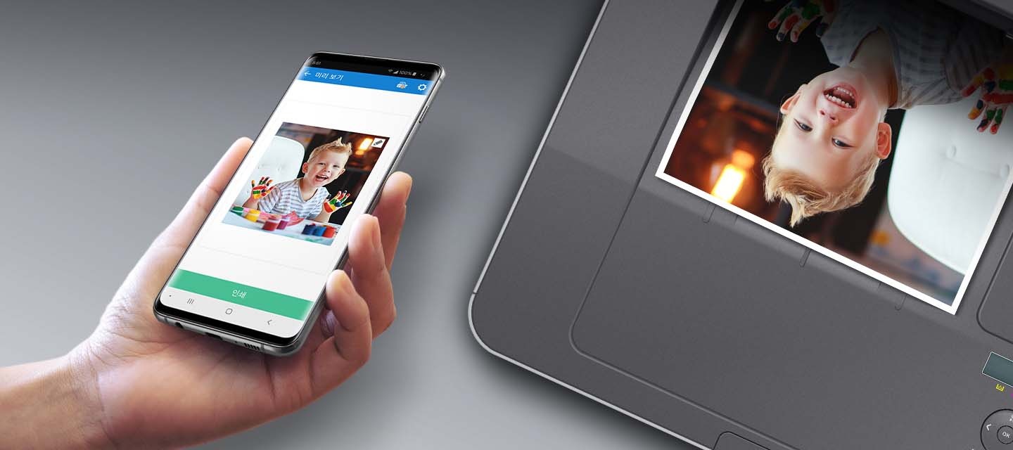 검정 색상의 나무 책상에 제품의 왼쪽 위에서 내려본 이미지가 있고 스마트폰을 제품 이미지 상단에 NFC 태그 스티커가 붙어있는 부분에 태그하는 이미지입니다.