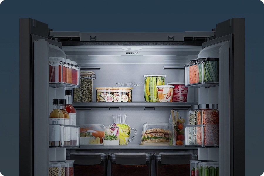 [김치냉장고 상칸 도어가 오픈되어 있고 안에 곡류, 야채 등 식재료가 가득 차 있는 이미지 입니다. 배경과 냉장고 내상이 어둡게 처리되어 있고 상단부 젠틀 라이팅이 은은하게 비춰주는 연출된 이미지 입니다.]