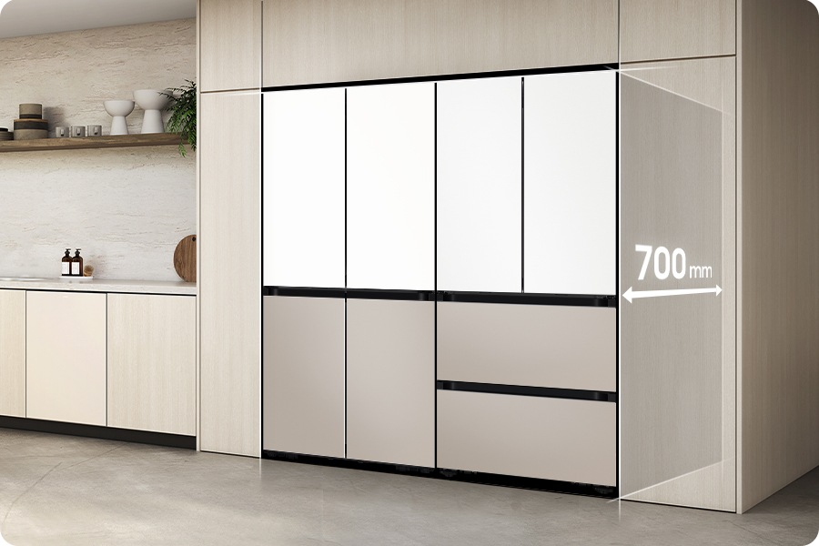 [밝은 우드톤 주방을 측면에서 바라본 이미지로, 밝은 우드톤 냉장고장에 에센셜화이트+에센셜 베이지 조합 4도어 냉장고와 김치냉장고가 페어 설치되어 있는 연출된 이미지 입니다. 냉장고장 안쪽으로 깊이 700mm 문구가 화살표와 함께 일러스트로 나와있습니다. 냉장고장 좌측으로는 동일한 톤의 하부장과 윗쪽 선반에 각종 오브제가 놓여있습니다.]