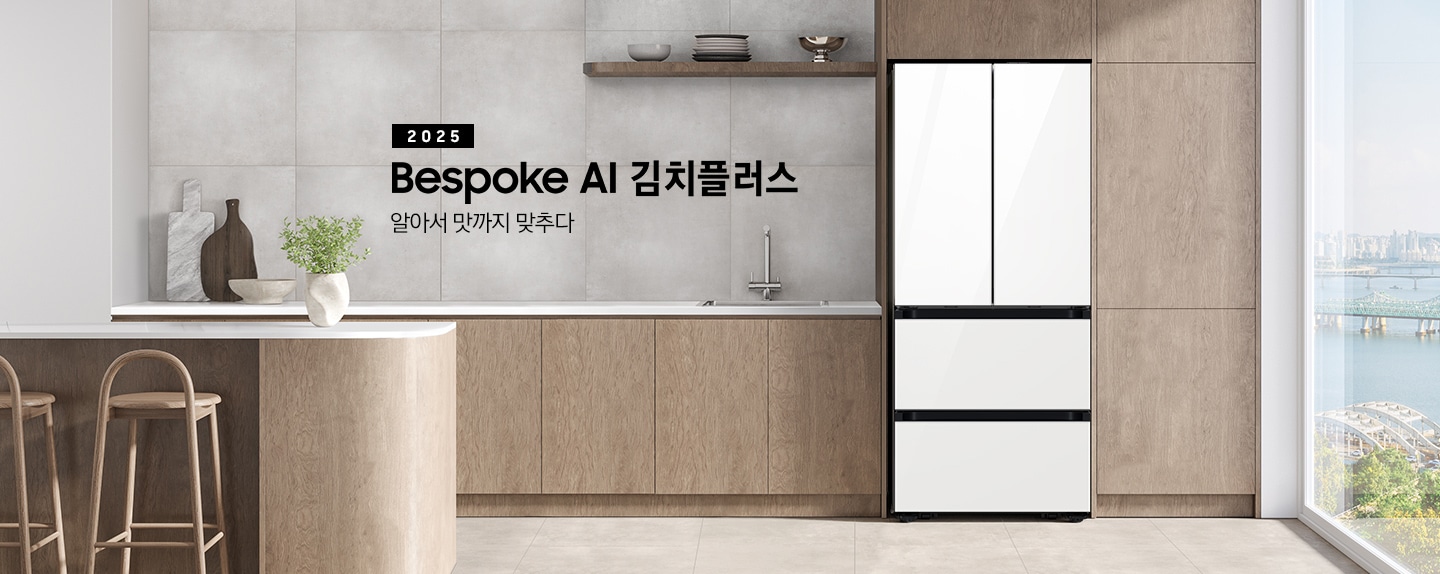 2025 Bespoke AI 김치플러스, 알아서 맛까지 맞추다- 프리스탠딩 KV 인테리어컷입니다. 우측에 Bespoke 김치플러스 4도어 제품이 프리스탠딩으로 설치되어 있습니다. 주방은 은은한 브라운톤의 장과 라이트 그레이 톤으로 이루어져 있으며, 김치냉장고가 설치되어 있는 우측에 바깥이 보이는 통창이 보여집니다. 김치냉장고 좌측에는 수전이 있는 싱크볼과 도마와 식기가 하부장 위에 올려져 있고, 앞쪽에는 아일랜드 식탁에 화분이 놓여져 있고, 의자 2개가 있습니다. 그리고 2층 수납장에 인테리어 소품과 접시, 그릇이 놓여져 있습니다.