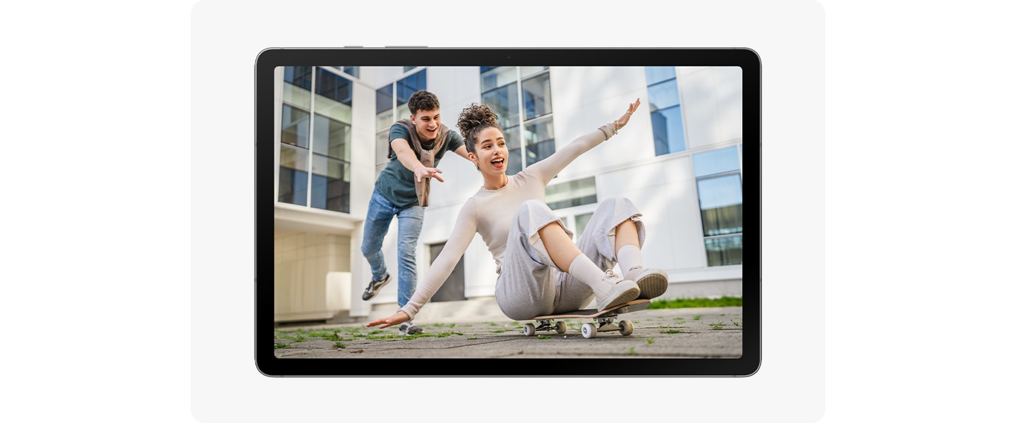 갤럭시 탭 S10 라이트 화면에 스케이트보드에 앉아 균형을 잡으려고 애쓰는 여성과 뒤에서 밀어주는 남성의 모습이 담긴 사진이 있습니다.