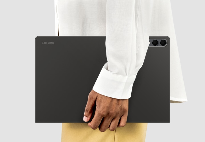 한 사람이 북커버를 장착한 갤럭시 탭 S11 울트라를 들고 있는 옆모습입니다. 일상 속 어디서나 휴대하기 편한 슬림하고 가벼운 디자인을 강조하고 있습니다. 